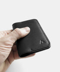 Porte-cartes cuir noir dans la main montrant taille compacte minimaliste