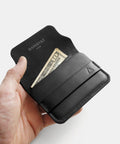 Porte-cartes cuir noir dans la main avec cartes format compact