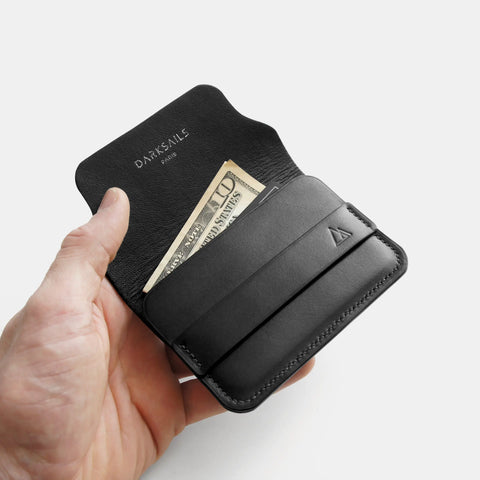 Porte-cartes cuir noir dans la main avec cartes format compact