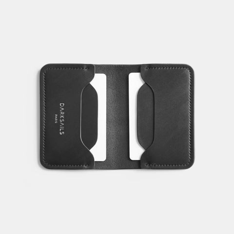 Porte-cartes cuir noir ouvert à plat montrant design bifold