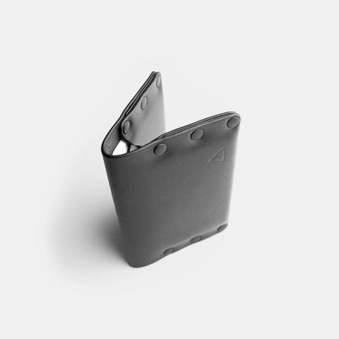Porte-cartes cuir noir debout montrant le détail des rivets
