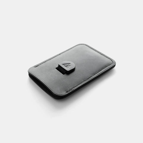 Slim black leather card holder with pull tab showing compact design
