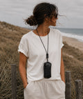 Femme portant un étui à lunettes cuir noir au cou, plage arcachon
