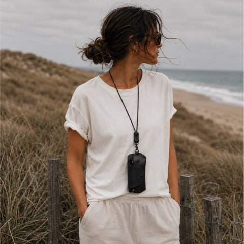 Femme portant un étui à lunettes cuir noir au cou, plage arcachon