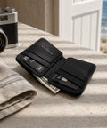 Portefeuille homme cuir noir ouvert avec cartes et billets sur table 