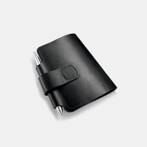 Protège-cahier cuir noir fermé avec boucle stylo et design minimaliste