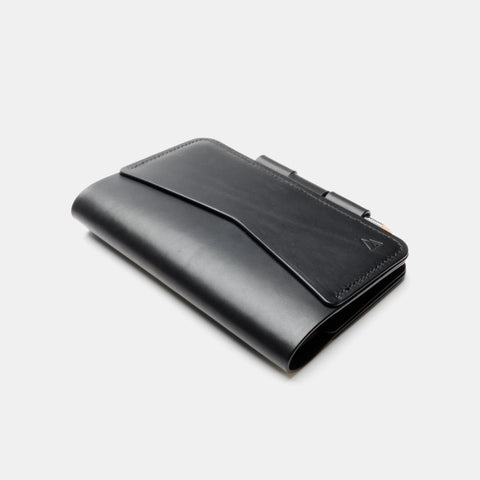 Black leather notebook cover with flap closure and pen lock mechanism