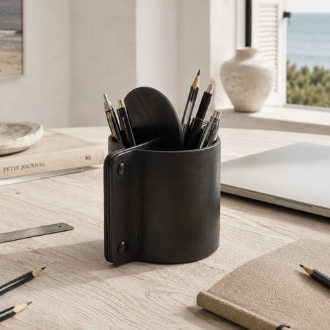 Pot à crayons en cuir noir avec crayons sur un bureau en bois
