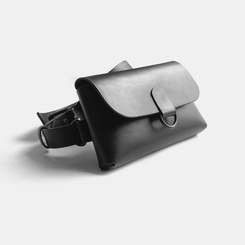 Leather belt bag open showing interior compartment and snap closure