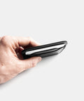 Leather card holder in hand showing compact minimalist design