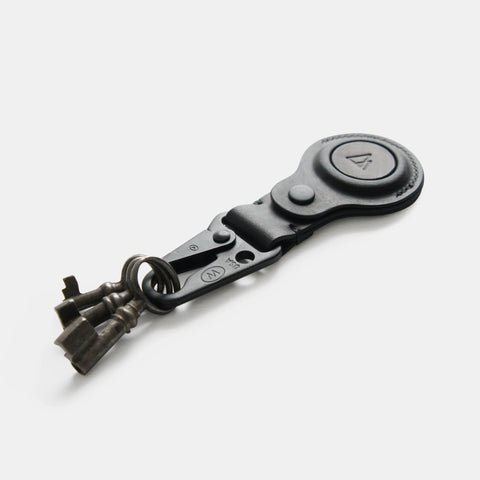 Leather AirTag keychain attached to vintage keys showing practical use