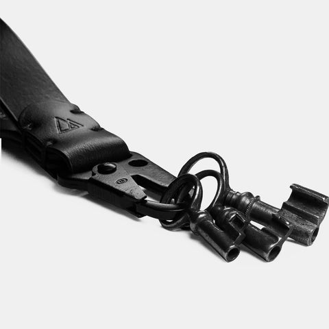 Leather lanyard snap hook close-up showing brass rivets and hardware