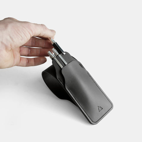 Handmade pen case open showing vegetable-tanned leather interior with pens