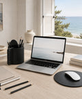 Tapis de souris rond en cuir noir sur bureau en bois avec vue océan