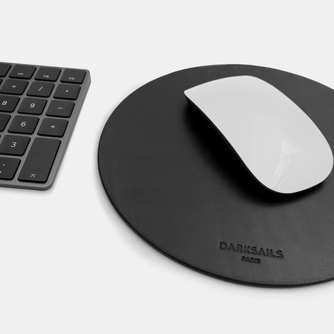 Round mousepad in black leather shown in desk workspace setup