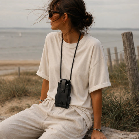 Femme portant l'étui téléphone tour de cou en cuir noir à la plage